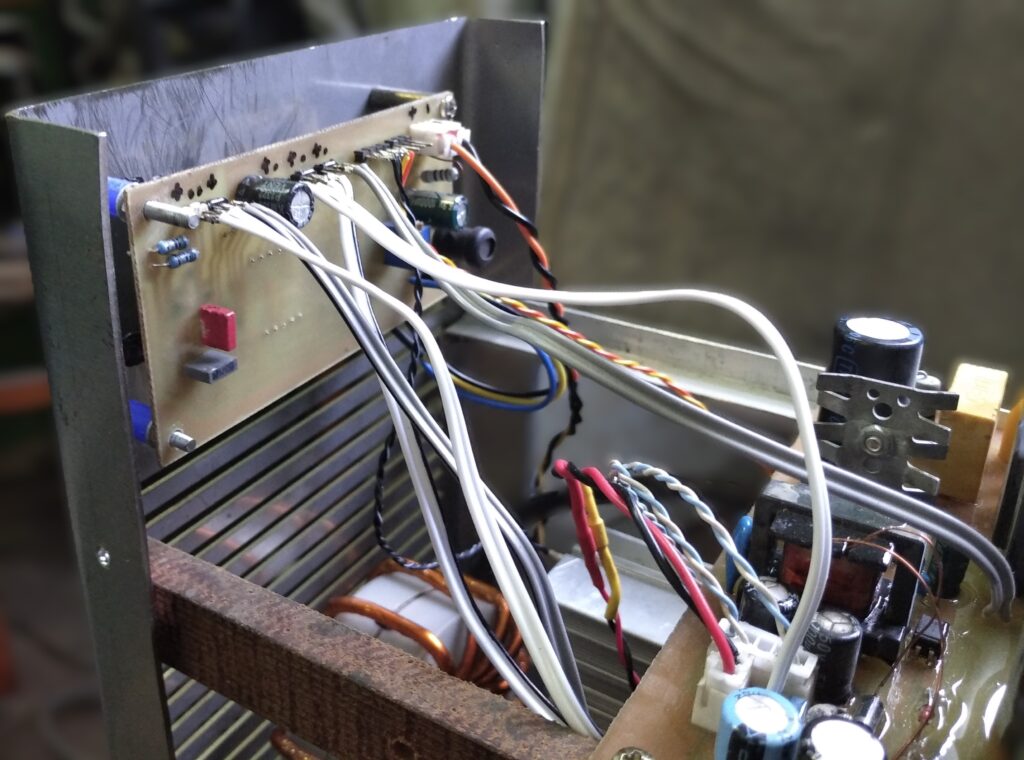 Detal montażu elektroniki, widoczne staranne luty i zabezpieczenia przewodów.
