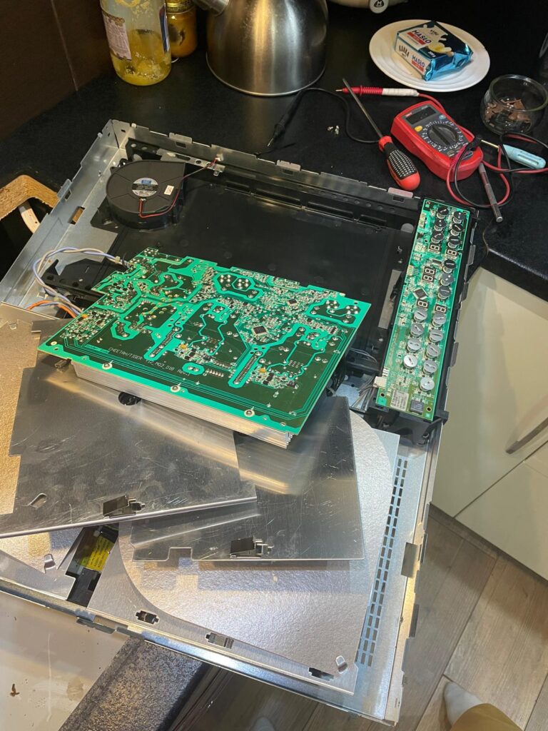 Rozmontowana płyta indukcyjna Electrolux z widocznymi płytkami elektronicznymi podczas naprawy u klienta.